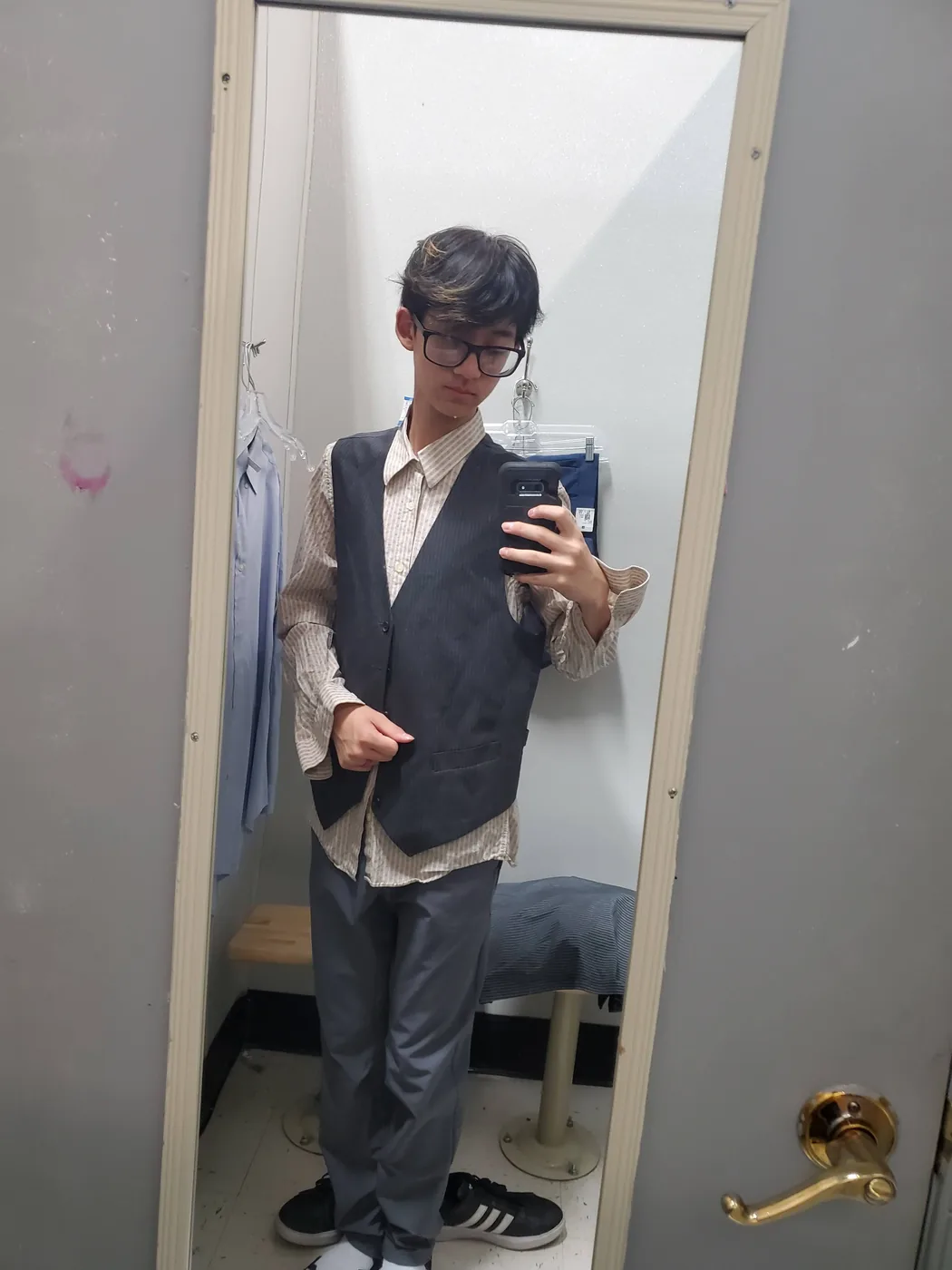 Aaron in a vest taking a mirror photo