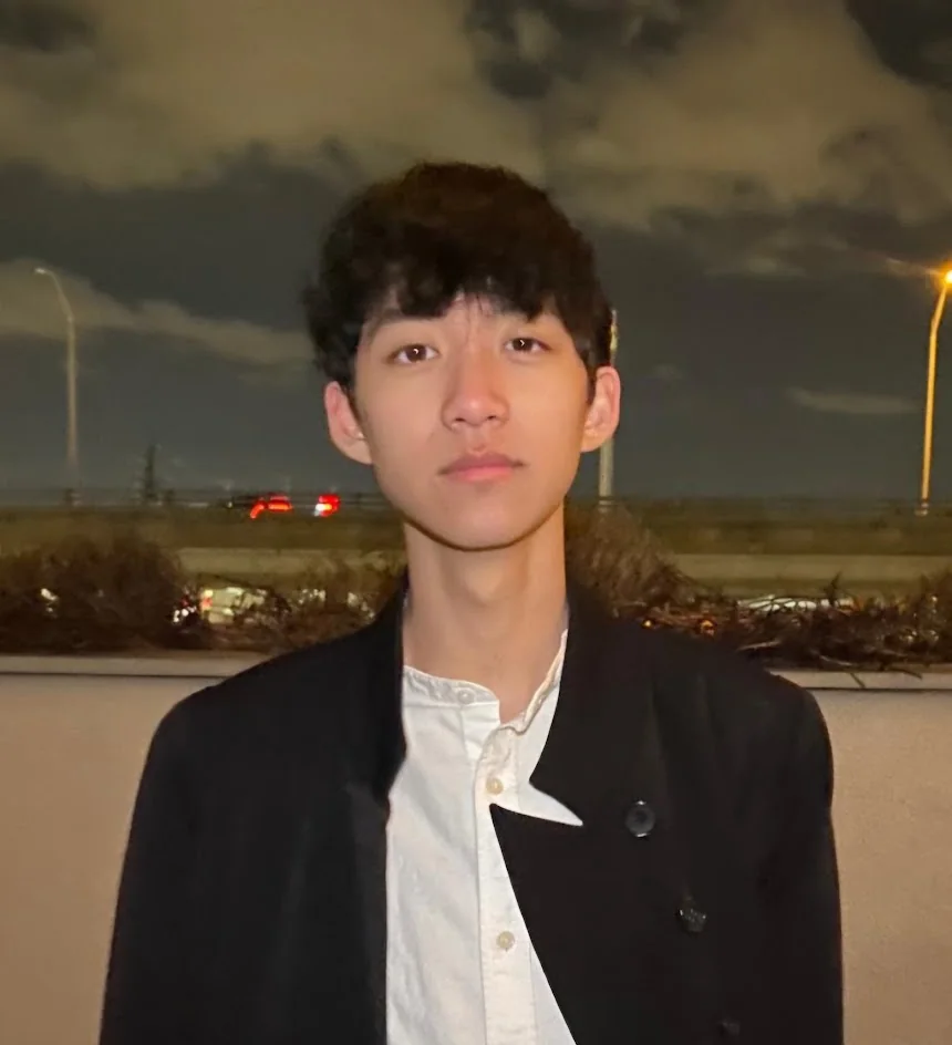 Portrait of Aaron at night in a dark jacket and white shirt