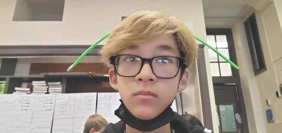 Aaron in class with two pencils balanced in his hair